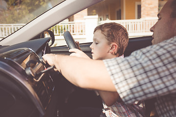 Image showing Happy father and son sitting in the car at the day time.