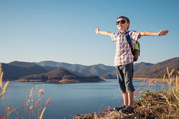 Image showing One happy little boy standing near a lake