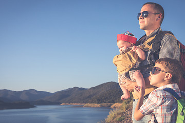 Image showing Happy family standing near the lake at the day time.