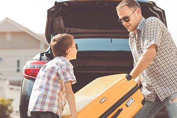 Image showing Happy father and son getting ready for road trip on a sunny day.