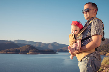 Image showing Happy family standing near the lake at the day time.