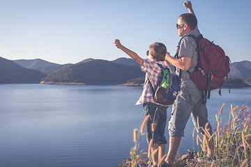 Image showing Happy family standing near the lake at the day time.