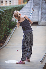 Image showing Happy little girl  playing mini golf.