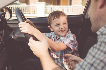 Image showing Happy father and son sitting in the car at the day time.