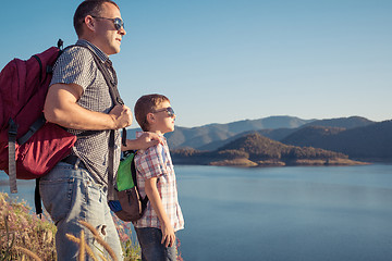 Image showing Happy family standing near a lake at the day time.