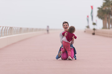 Image showing mother and cute little girl on the promenade by the sea