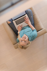 Image showing Young woman using laptop at home top view