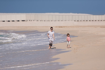 Image showing mother and daughter running on the beach