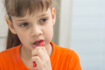 Image showing Seven-year-old girl enthusiastically brushes teeth