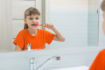 Image showing Girl waking up in the morning brushing her teeth in the bathroom