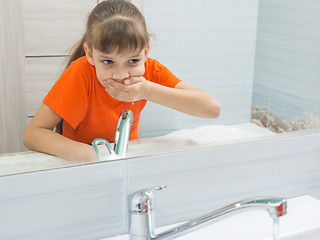 Image showing The girl rinses her mouth after brushing her teeth