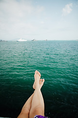 Image showing Crop female feet above sea water