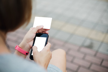 Image showing Woman using phone and card for shopping