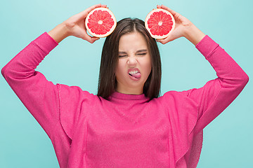 Image showing Pretty woman with delicious grapefruit in her arms.