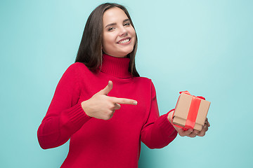 Image showing Portrait of happy young woman holding a gift isolated on white