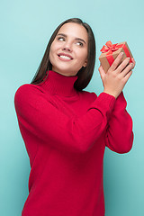 Image showing Portrait of happy young woman holding a gift isolated on white