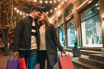 Image showing The happy couple with shopping bags enjoying night at city background