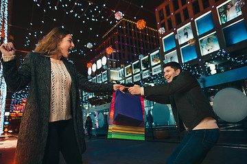 Image showing The happy couple with shopping bags enjoying night at city background