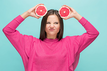 Image showing Pretty woman with delicious grapefruit in her arms.