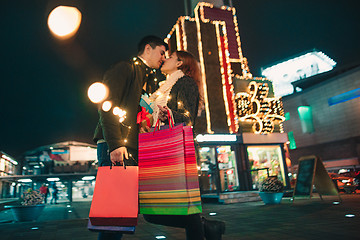 Image showing The happy couple with shopping bags enjoying night at city background