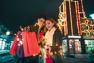 Image showing The happy couple with shopping bags enjoying night at city background