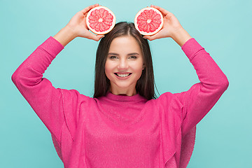 Image showing Pretty woman with delicious grapefruit in her arms.