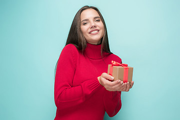 Image showing Portrait of happy young woman holding a gift isolated on white