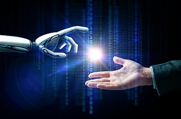 Image showing robot and human hand flash light and binary code