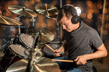 Image showing musician playing drum kit at concert over lights