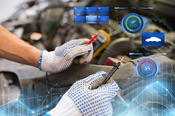 Image showing auto mechanic man with multimeter testing battery