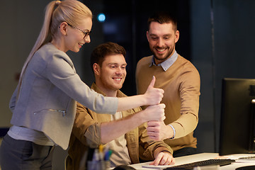 Image showing business team making thumbs up gesture at office