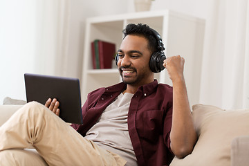 Image showing man in phones with tablet pc listening to music