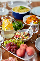 Image showing salad, jug of water and other food on wooden table