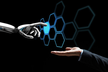 Image showing human hand and robot touching network hologram