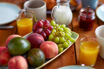 Image showing fruits, juice and other food on table at breakfast