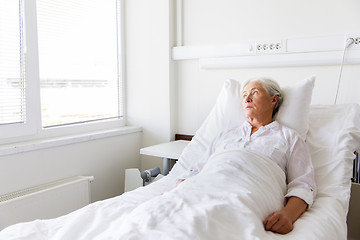 Image showing sad senior woman lying on bed at hospital ward