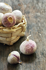 Image showing Fresh purple garlic in a small straw basket 