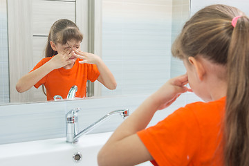 Image showing Seven-year-old girl washes in the bathtub, washes water face