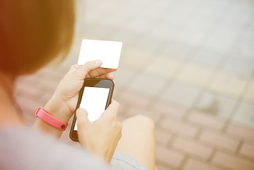 Image showing Woman using phone and card for shopping