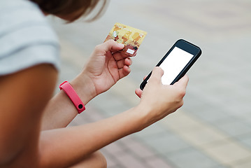 Image showing Woman using phone and card for shopping