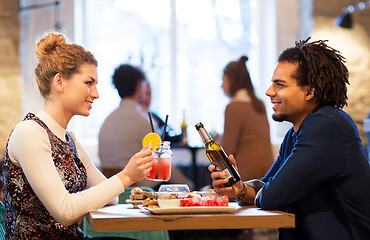 Image showing happy couple with drinks at restaurant or bar