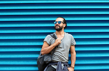 Image showing man in sunglasses with bag standing at street wall