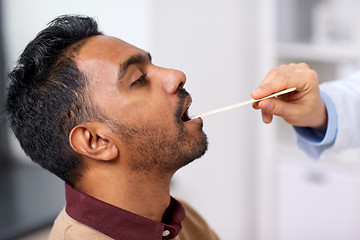 Image showing doctor hand examining patient throat at clinic