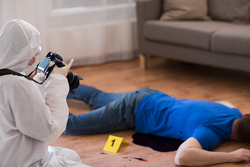 Image showing criminalist photographing dead body at crime scene