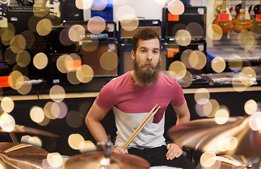 Image showing male musician with cymbals at music store