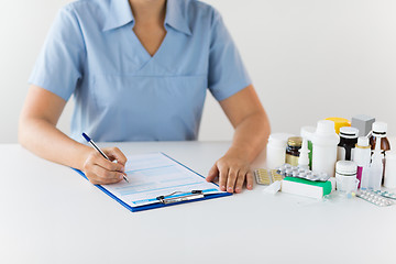 Image showing doctor with medicines and clipboard at hospital