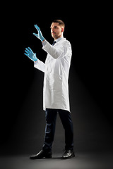 Image showing doctor or scientist in lab coat and medical gloves