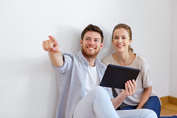 Image showing happy couple with tablet pc computer at new home