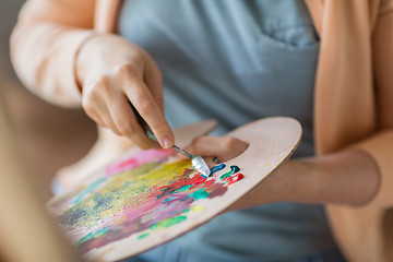 Image showing artist with palette knife painting at art studio