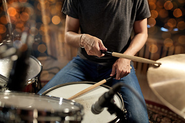 Image showing musician playing drum kit at concert over lights